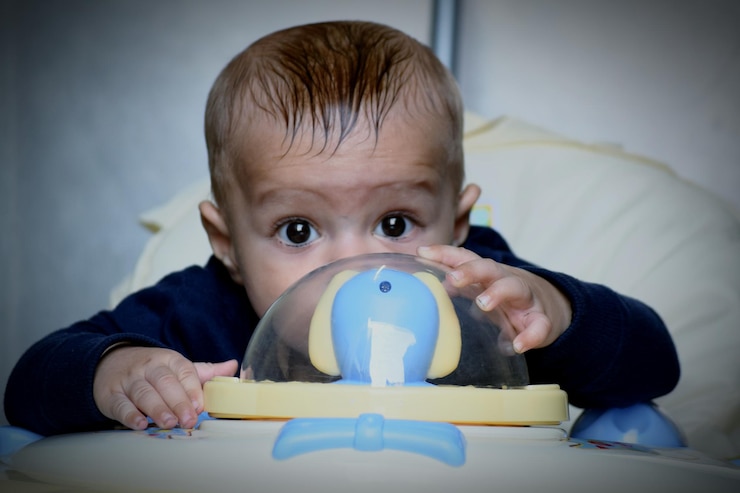 Foto portret van een schattige baby met speelgoed thuis