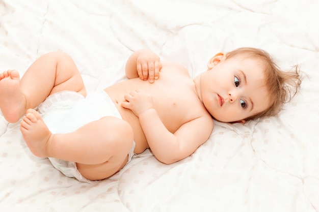 Portret van een schattige baby van 6 maanden die op een deken ligt. kleine blije baby