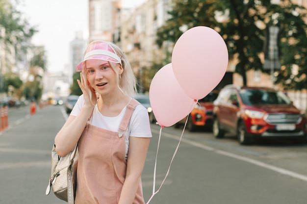 Portret van een schattige dame op straat met ballonnen