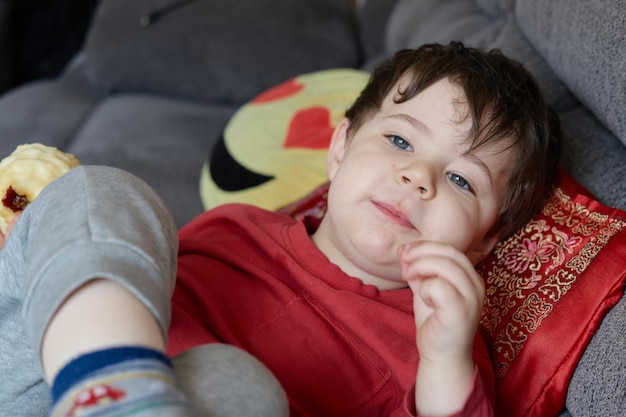 Foto portret van een schattige jongen die op bed ligt