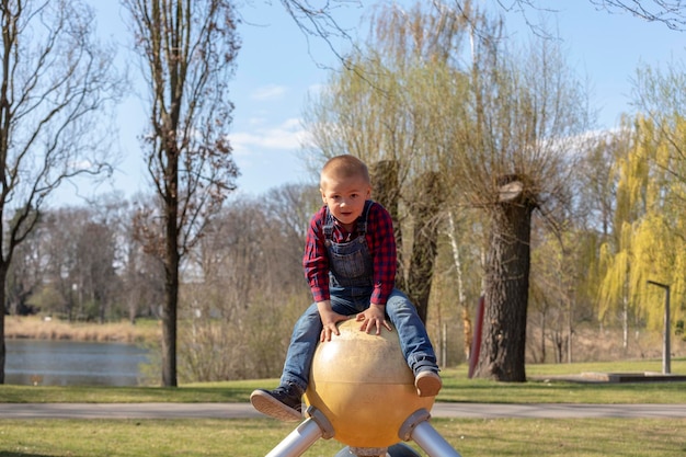 Foto portret van een schattige jongen die op de speeltuin speelt