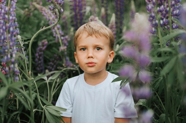 Portret van een schattige kleine gelukkige jongen met lupine bloei