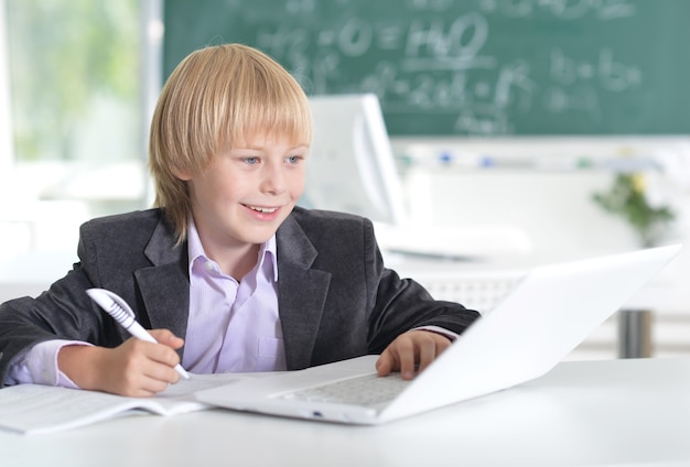 Portret van een schattige kleine jongen die een laptop gebruikt