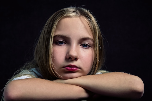 Foto portret van een schattige peinzende tiener met lang haar.