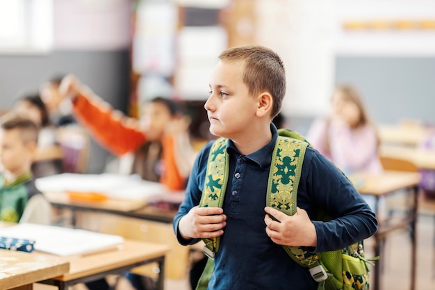 Portret van een schooljongen in de klas met rugzak