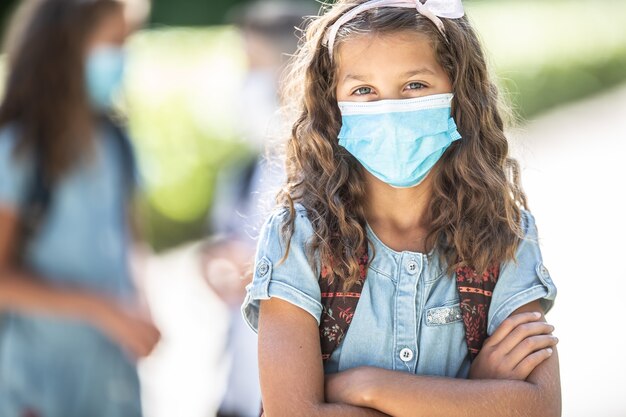 Portret van een schoolmeisje met gezichtsmasker tijdens Covid-19 quarantaine.