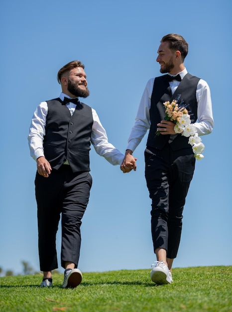 Foto portret van een sensueel homopaar verliefd op de homoseksuele bruidegoms van de trouwdag die samen lopen op de trouwdag hom