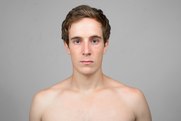 Portret van een shirtloze man op een witte achtergrond.