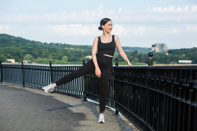 Portret van een slank jong meisje na het joggen in een openluchtpark op een heldere zonnige dag