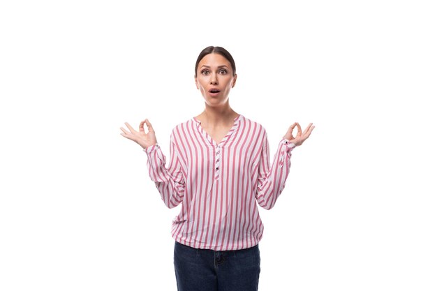 Portret van een slanke verraste jonge brunette kantoormedewerker vrouw, gekleed in een shirt met strepen