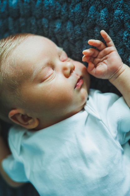 Foto portret van een slapende baby een pasgeboren baby slaapt een baby in een wit katoenen bodysuit
