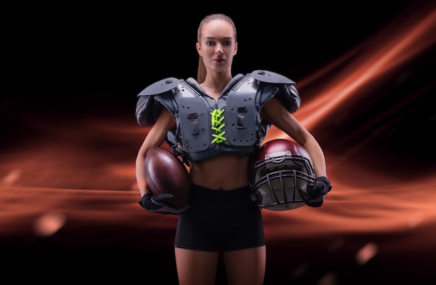 Portret van een sportief meisje in het uniform van een american football-teamspeler. sportconcept. futuristische achtergrond. gemengde media