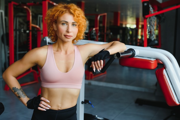 Portret van een sportieve vrouw met rood haar in de sportschool