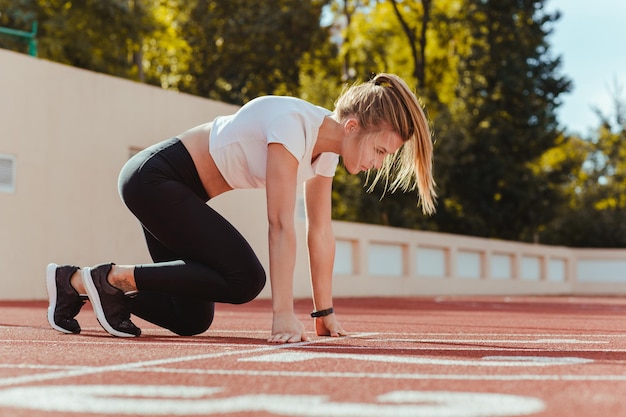 Portret van een sportvrouw in startpositie voor run