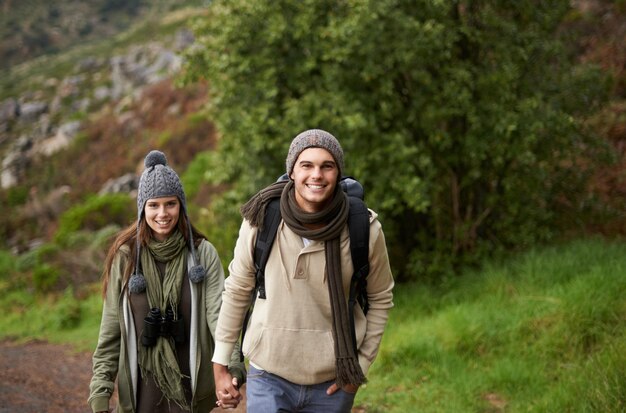 Portret van een stel en wandelen op de berg of hand in hand met reis avontuur of vakantie voor ervaring of fitness Man vrouw of trekking buiten op het pad voor cardio oefening of workout met liefde