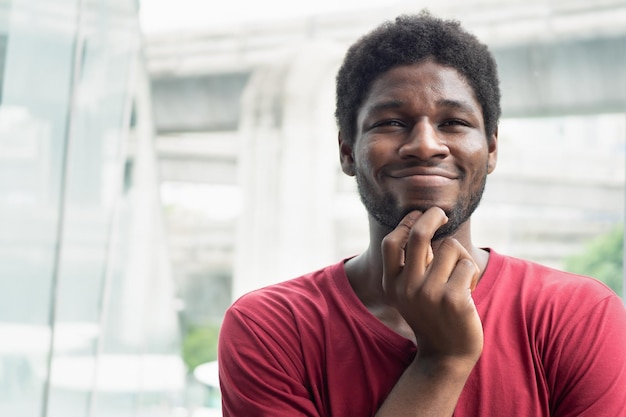 Portret van een sterke en gezonde Afrikaanse zwarte man in een stadsomgeving, Afro-zwarte man met een blij lachende zelfverzekerde gezichtsuitdrukking