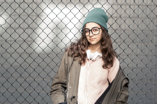 Portret van een stijlvolle tiener hipster meisje in een hoed. Jonge modieuze vrouw in glazen