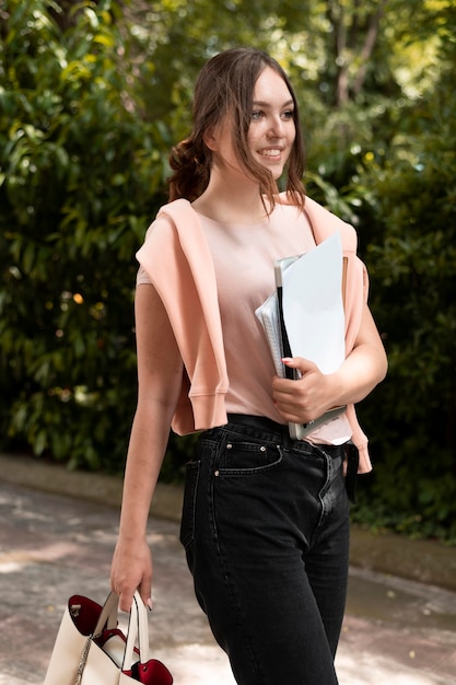 Foto portret van een student die wat boeken vasthoudt