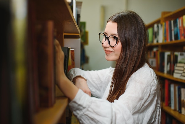 Portret van een studentenmeisje dat aan de bibliotheek studeert