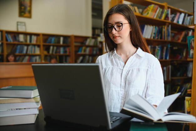 Portret van een studentenmeisje dat aan de bibliotheek studeert