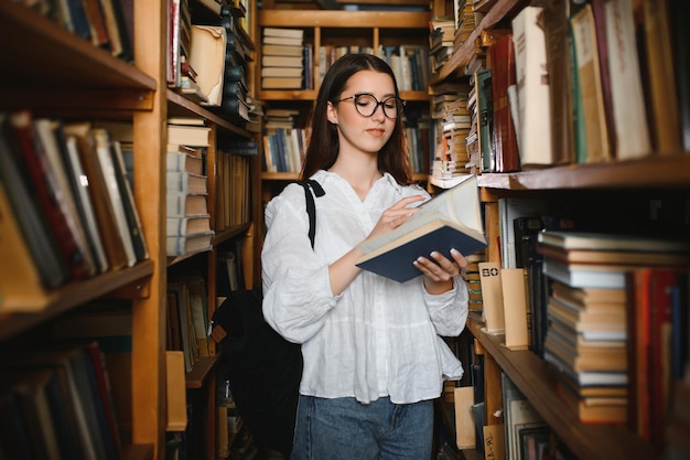 Portret van een studentenmeisje dat aan de bibliotheek studeert