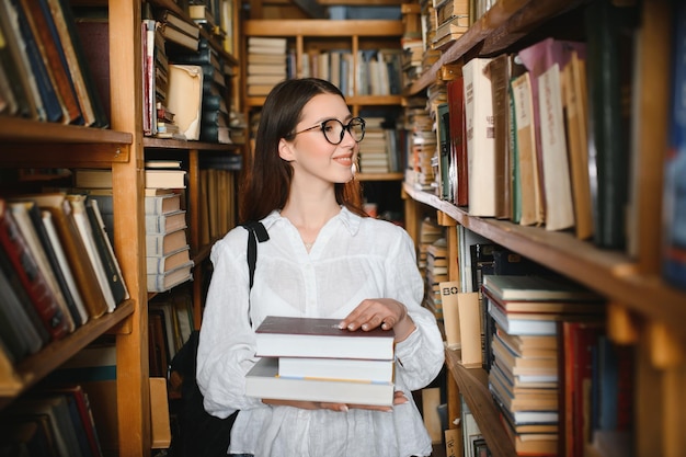 Portret van een studentenmeisje dat aan de bibliotheek studeert