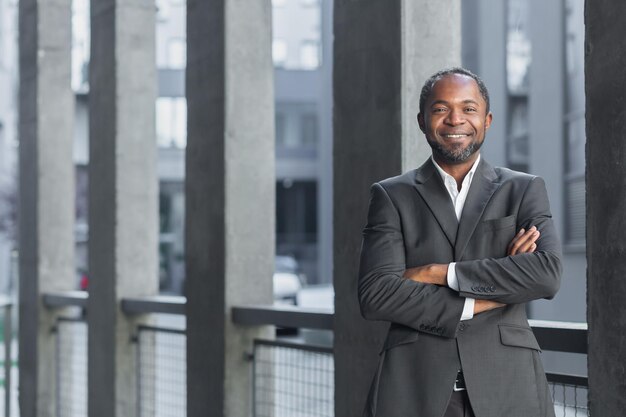 Portret van een succesvolle Afro-Amerikaanse zakenman man in pak glimlachend en kijkend naar