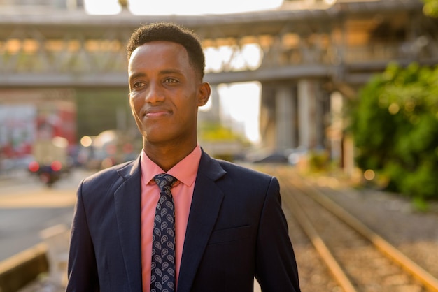 Portret van een succesvolle jonge Afrikaanse zakenman die een pak en stropdas draagt terwijl hij nadenkt