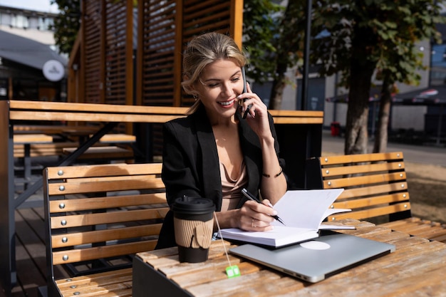 Portret van een succesvolle jonge vrouw die in een café werkt met een laptop