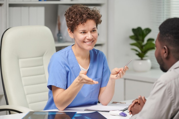 Foto portret van een succesvolle volwassen blanke vrouwelijke medisch specialist die aan tafel zit voor unrec