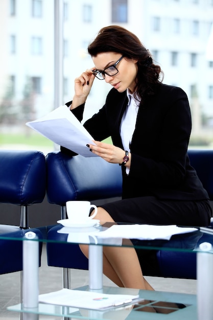 Portret van een succesvolle vrouw die op kantoor zit