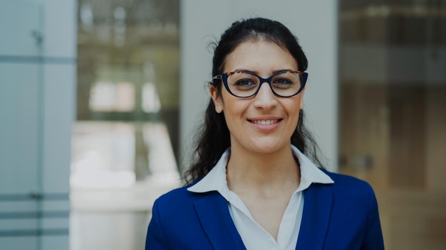 Portret van een succesvolle zakenvrouw met een bril die lacht in een modern kantoor