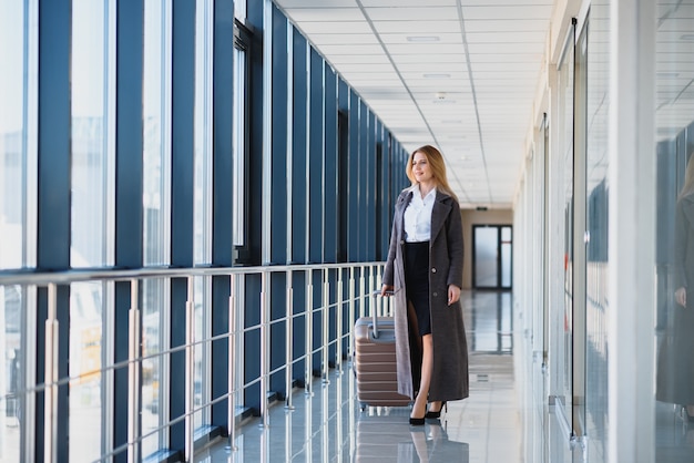 Portret van een succesvolle zakenvrouw reizen met koffer op de luchthaven