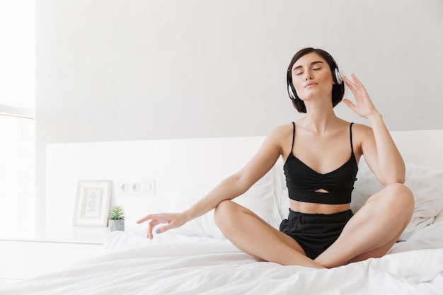 Portret van een tevreden jonge vrouw die aan muziek luistert