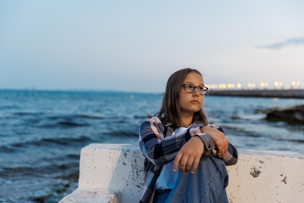 Portret van een tienermeisje aan zee op een zomeravond