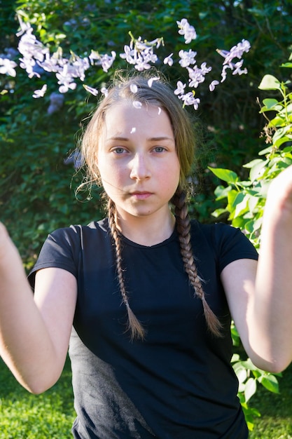 Foto portret van een tienermeisje dat bloemen gooit in het park