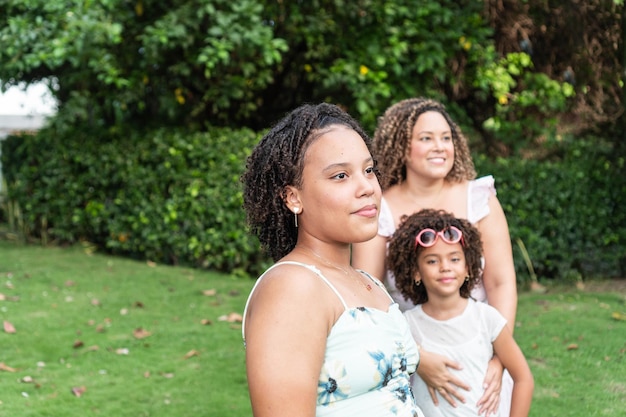 Portret van een tienermeisje dat in het park staat met haar familie op de achtergrond