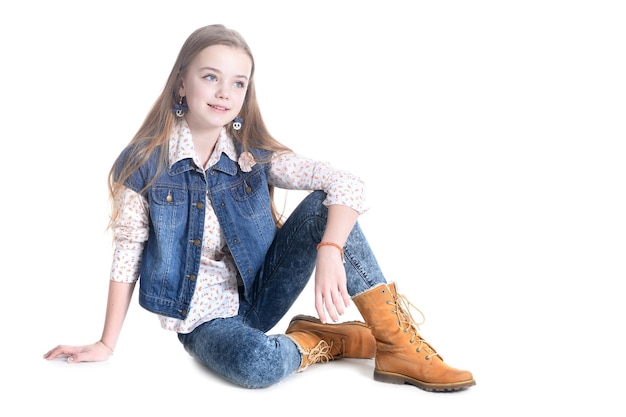 Portret van een tienermeisje zittend op de vloer op een witte achtergrond