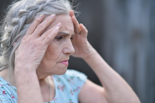 Portret van een trieste senior mooie vrouw in park