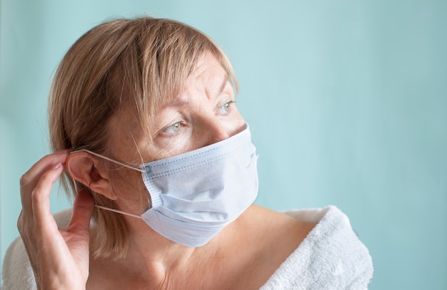 Portret van een trieste vrouw die een medisch masker draagt vanwege de coronavirus-epidemie