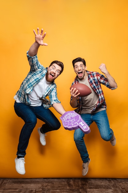 Portret van een twee gelukkige jonge mannen springen