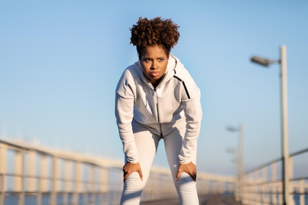 Foto portret van een vermoeide zwarte vrouw die ontspant na buiten te joggen