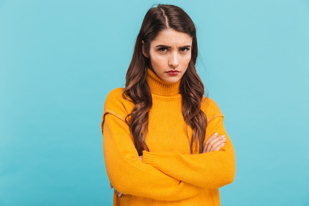 Portret van een verstoorde jonge vrouw in trui met gevouwen armen