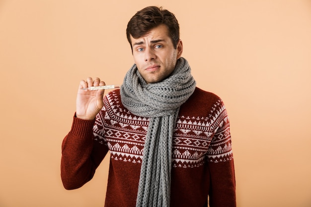 Portret van een verwarde zieke jonge man gekleed in een trui