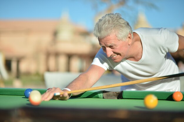 Portret van een volwassen man die buiten pool speelt