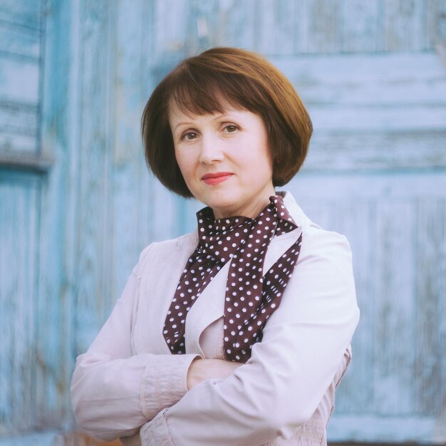 Foto portret van een volwassen vrouw die tegen de muur staat