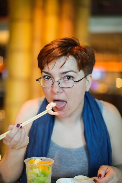 Foto portret van een volwassen vrouw die zeevruchten eet in een restaurant