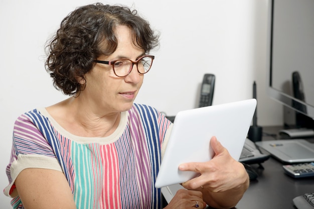 Portret van een volwassen vrouw met een digitale tablet