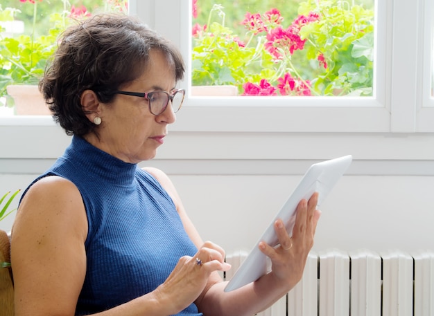 Portret van een volwassen vrouw met een tablet