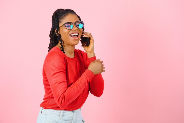 Portret van een vrij vrolijk meisje dat aan de telefoon praat over nieuws cellulair geïsoleerd over roze pastelkleurige achtergrond